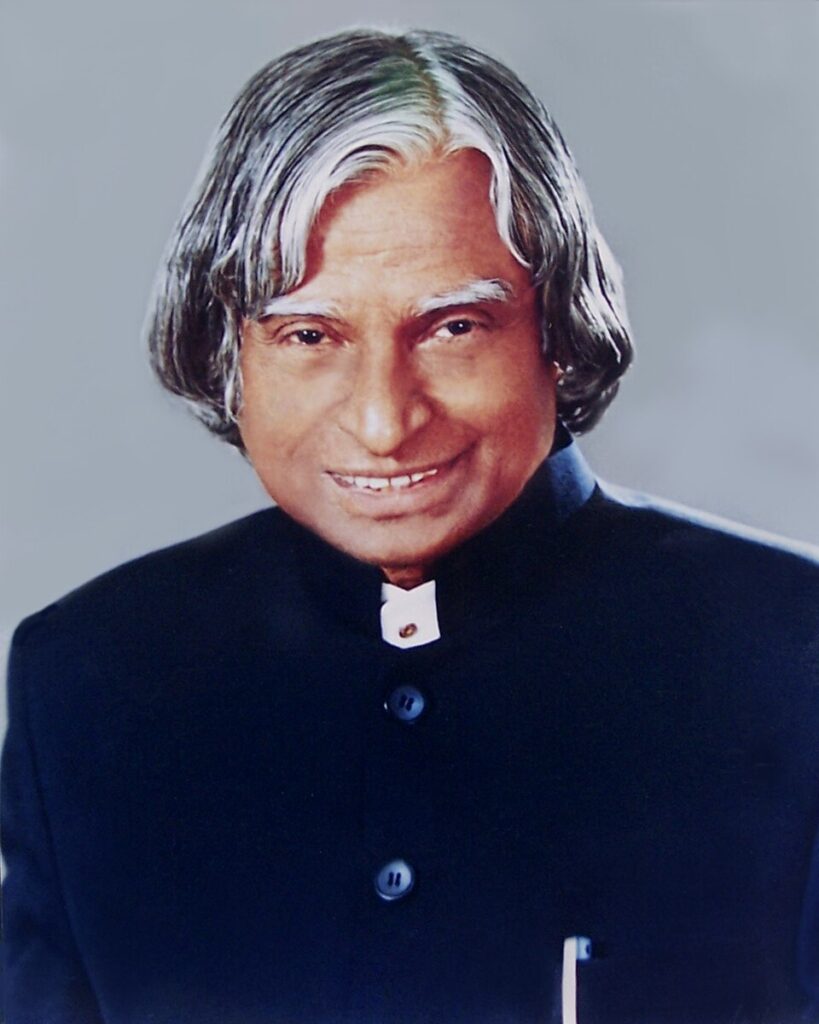 A formal portrait of an elderly Indian statesman with silver hair, wearing a dark suit and smiling gently at the camera.